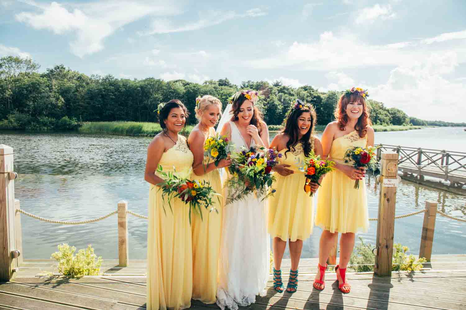 Bridesmaids wearing yellow by the water at Boathouse Ormesby Wedding Photographer