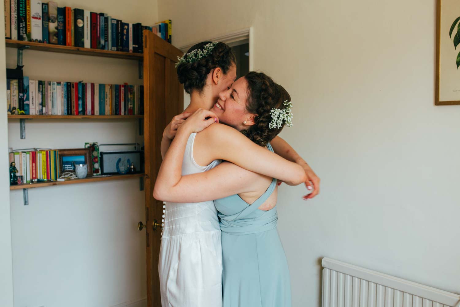 Bride and bridesmaid hugging Norwich Plantation Gardens Wedding Photographer