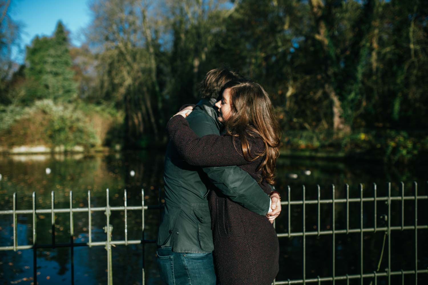 couple in love hugging by a lake in suffolk christchurch park