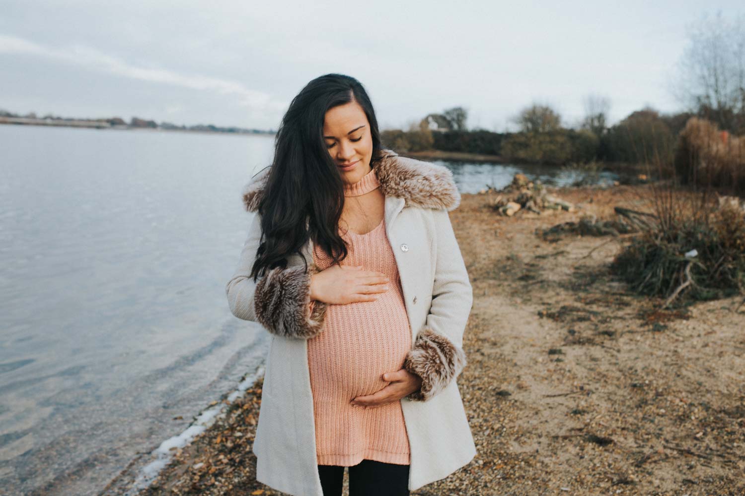 pregnant mum to be holding her bump at alton water in ipswich, suffolk