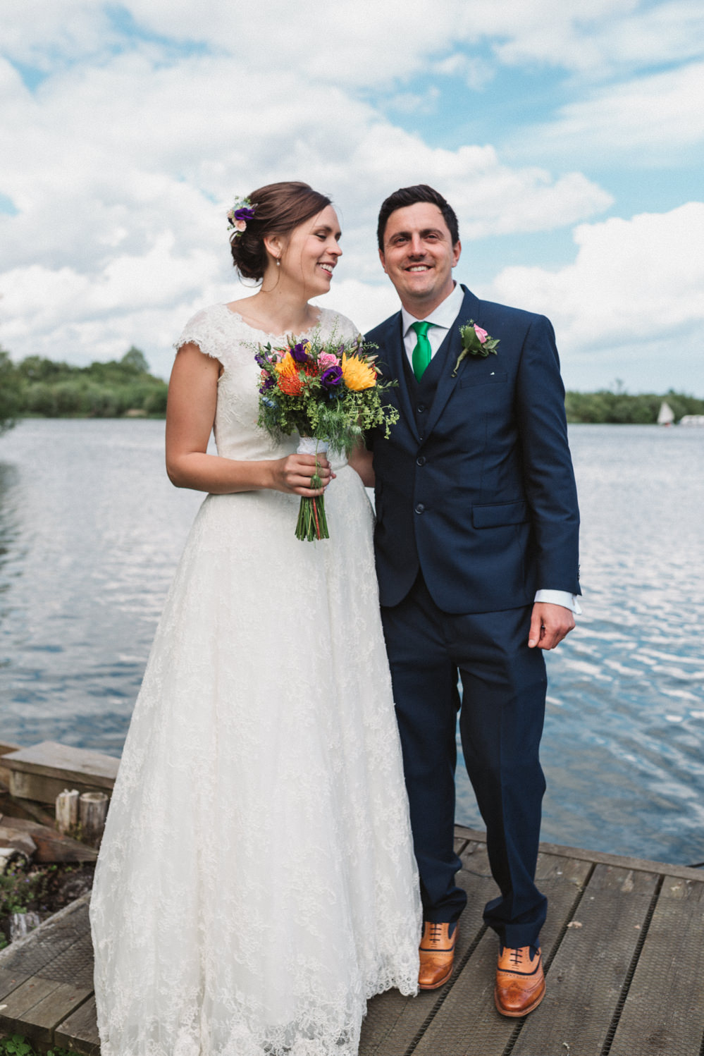 Relaxed couples bridal portraits in front of water by norfolk wedding photographer emily tyler