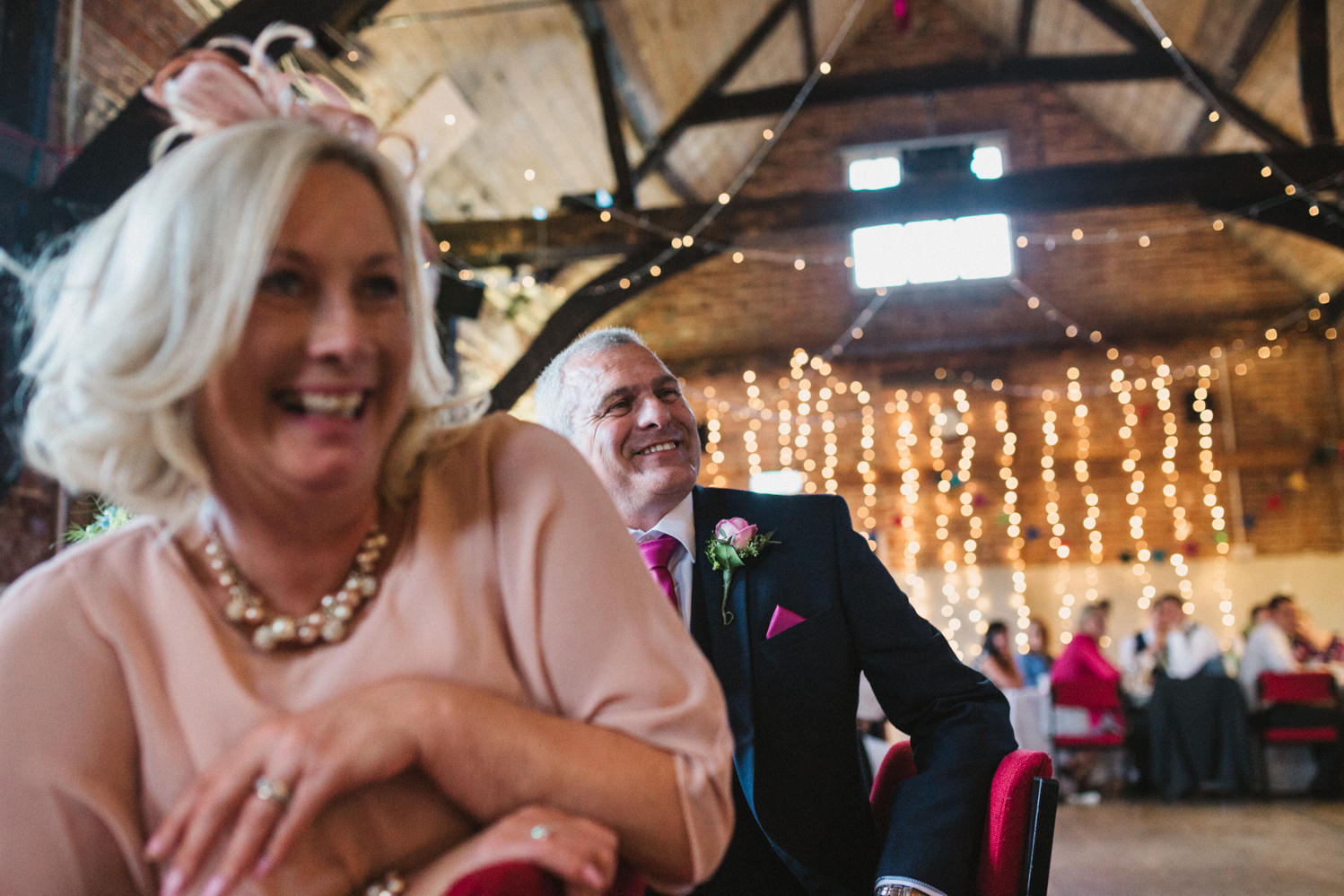 Guests at Norfolk suffolk relaxed tithe barn wedding guests laughing