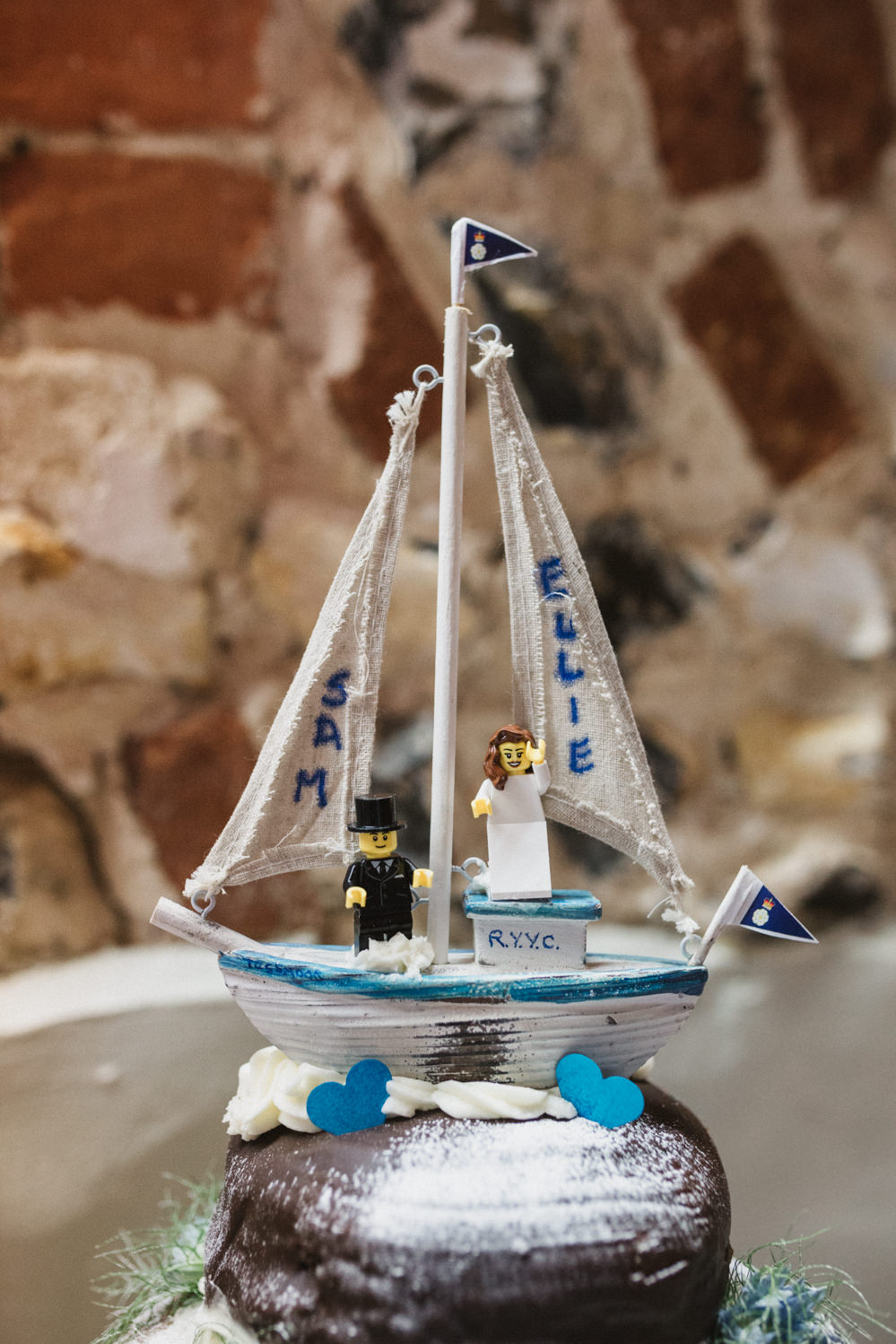 Guests at Norfolk suffolk relaxed tithe barn wedding boat lego cake topper