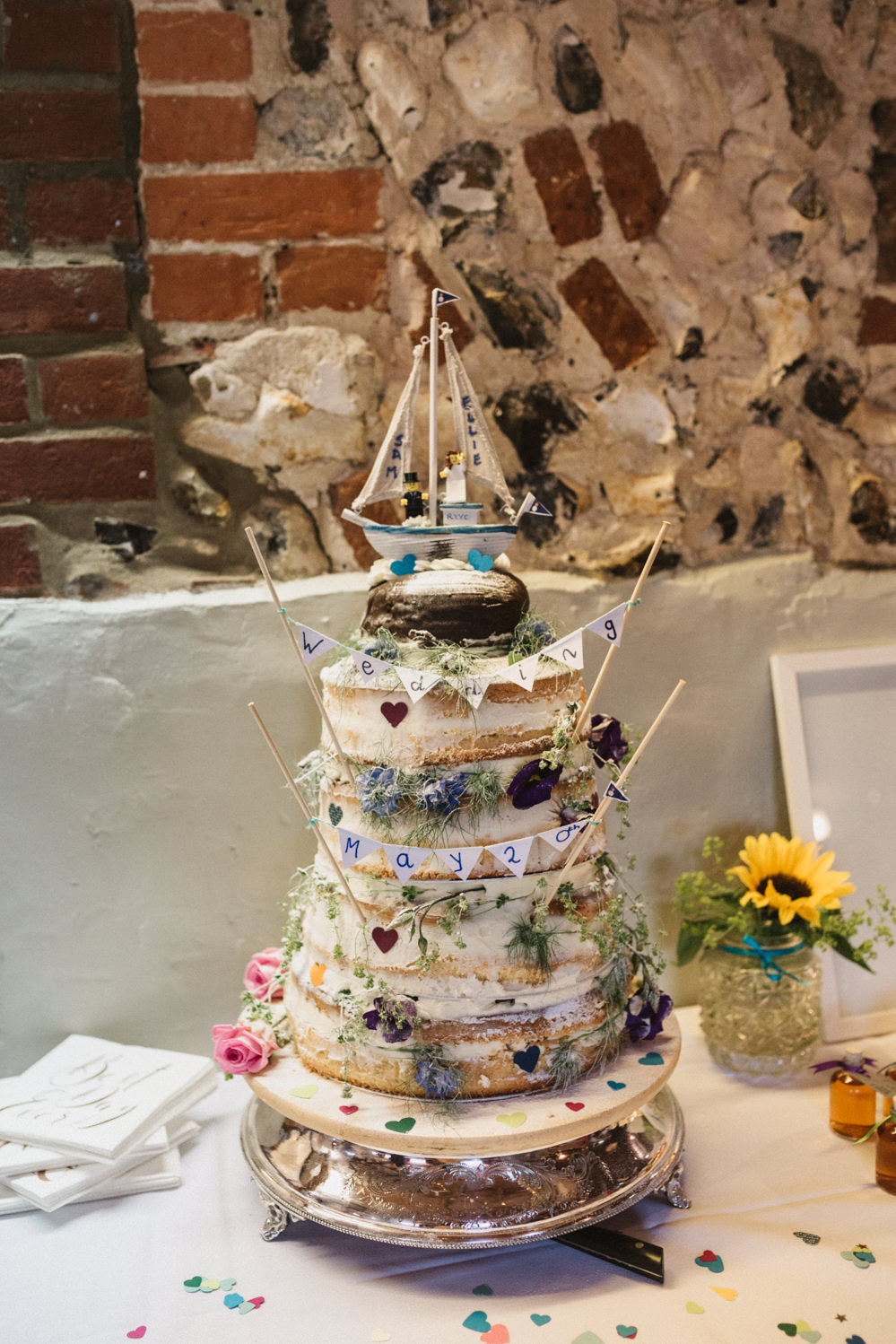 Naked floral wedding cake with boat lego topper