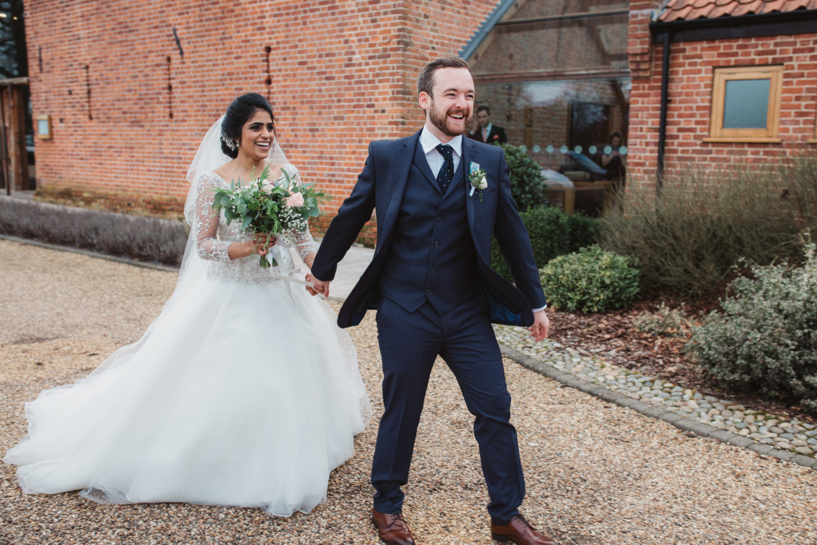 laughing newlyweds outside their winter wedding at southwood hall in norfolk