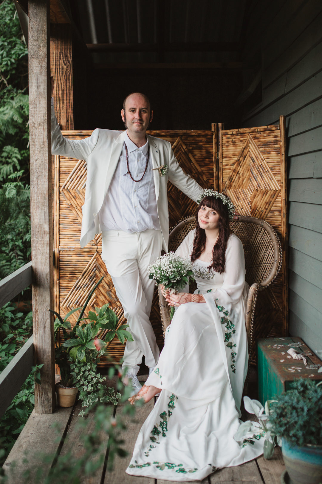 bride and groom wearing white bohemian wedding portrait
