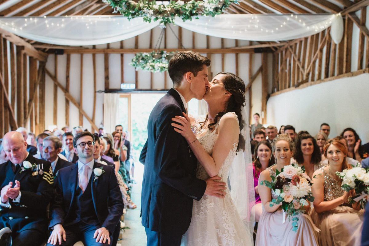 first kiss at the ceremony at bride and groom portraits at HAUGHLEY PARK BARN WEDDING PHOTOGRAPHY