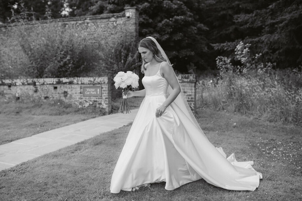 bride walking in countryside black and white wedding photo