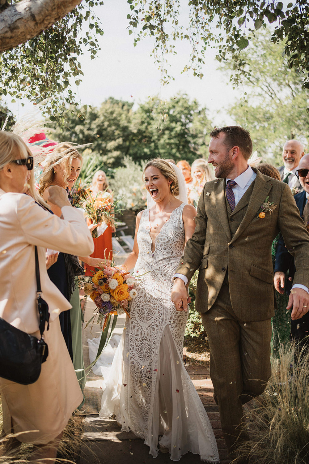 relaxed documentary wedding photographer in suffolk confetti throw over bride and groom